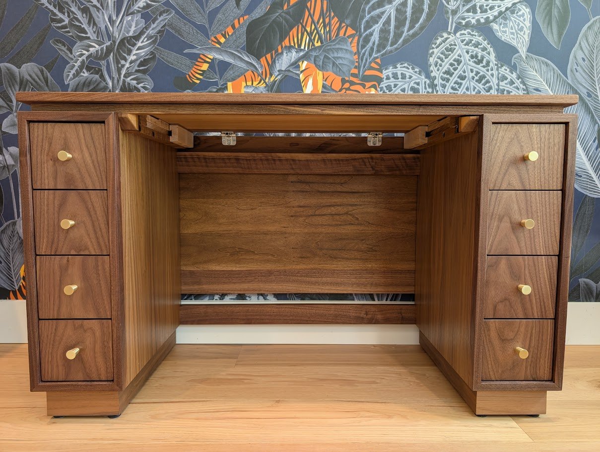 Expandable walnut desk with brass inlay top and continuous grain drawers