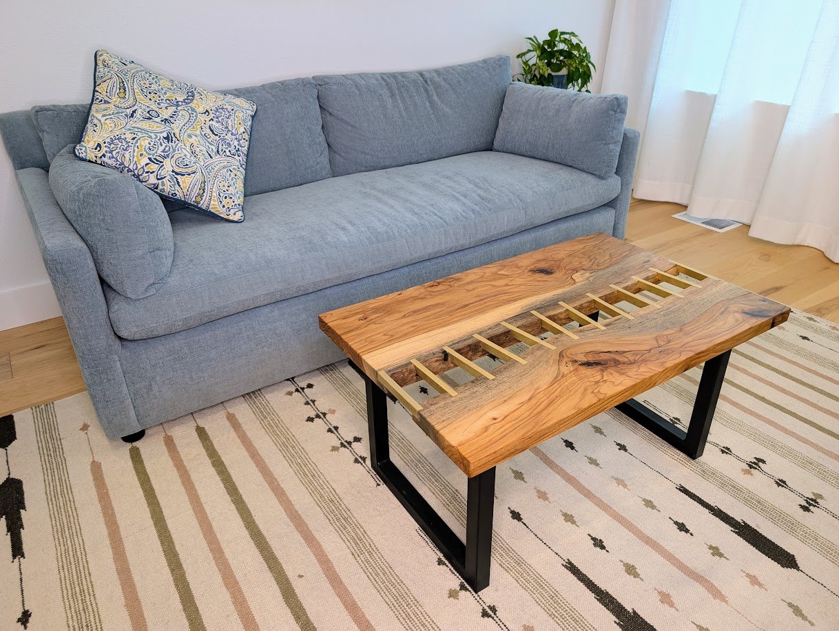 Brass stitched river table in room