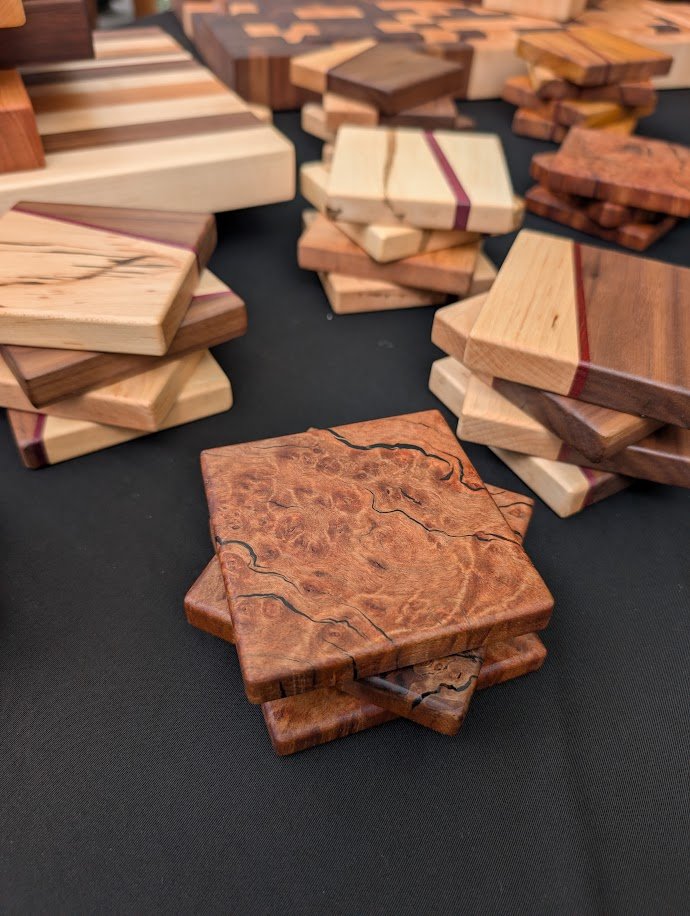 Hardwood coaster sets including burled wood